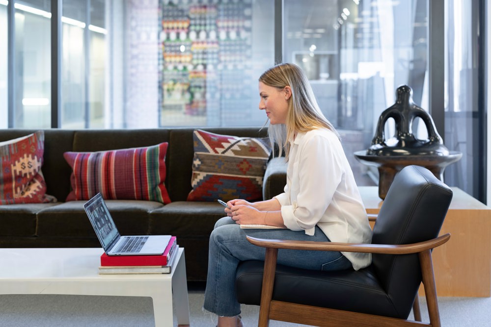 Woman siting on a chair and looking to a computer