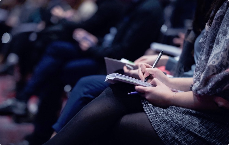 Attendee taking notes at a conference