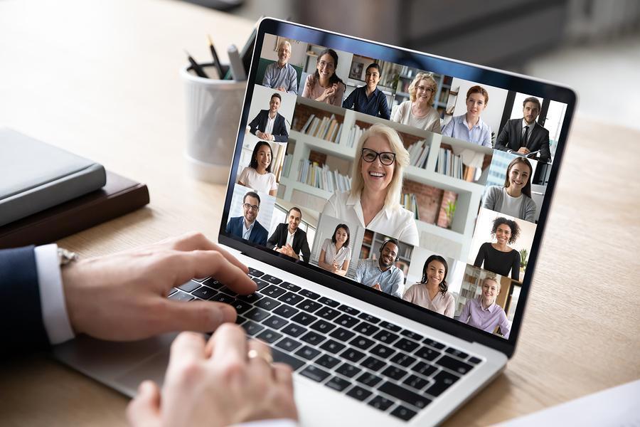 Person attending a virtual conference on her keyboard